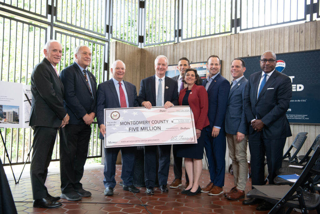 County executives and leadership hold up large check.