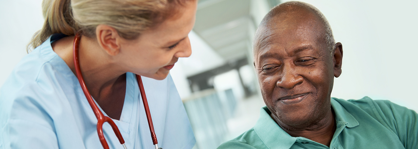 Female nurse and an African American man smiling.