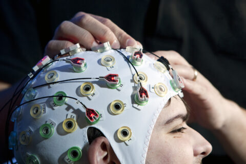 EEG brain monitoring cap on bioengineering doctoral student Male doctoral student pictured wearing a brain monitoring cap.