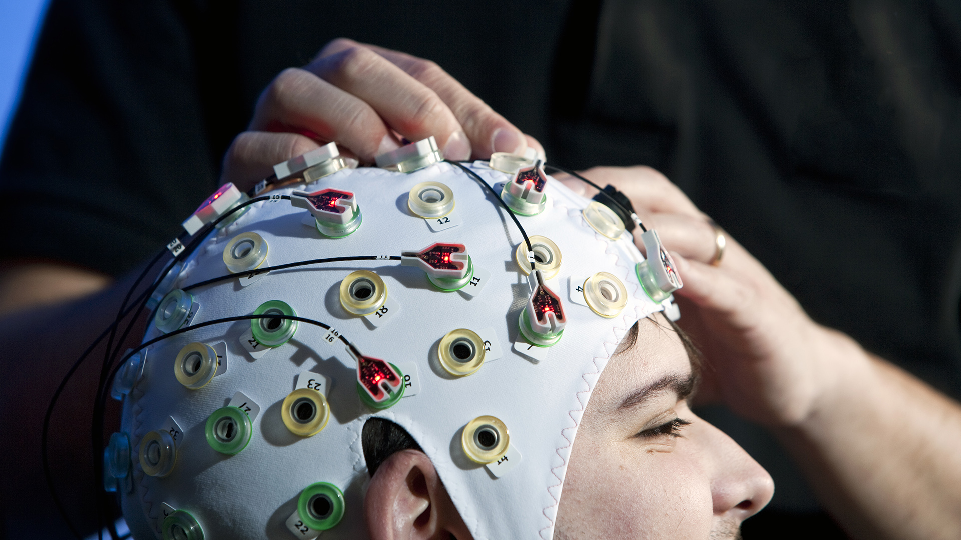 Male doctoral student pictured wearing a brain monitoring cap.