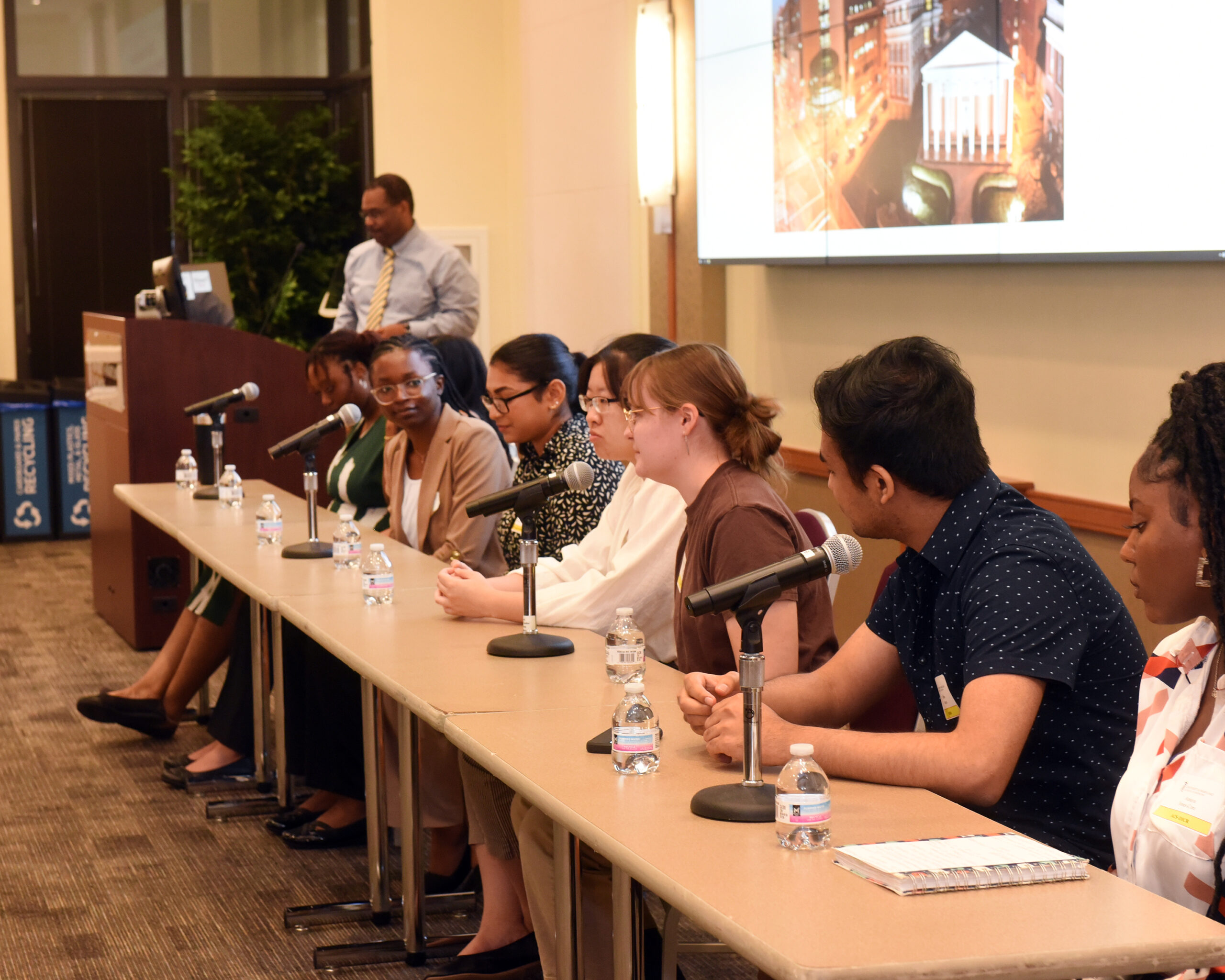 Student panel discussion with eight students seated at a table with microphones.