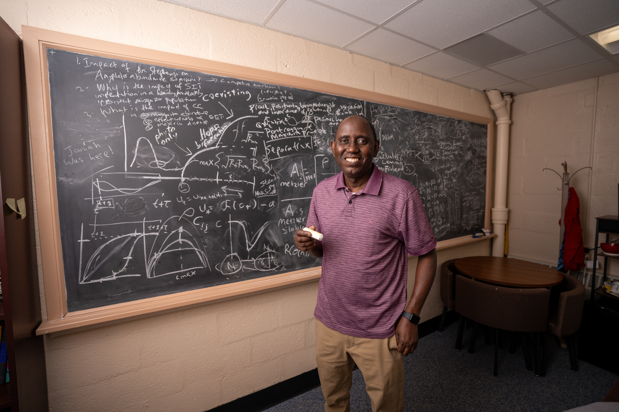 Man pictured in front of a chalkboard.