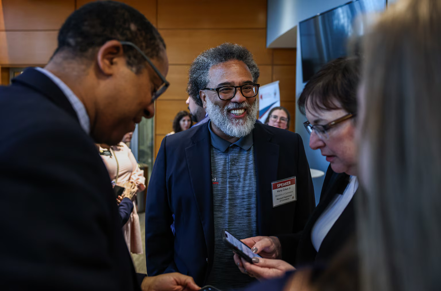 Maryland Secretary of Commerce Harry Coker Jr. speaks to man and woman.