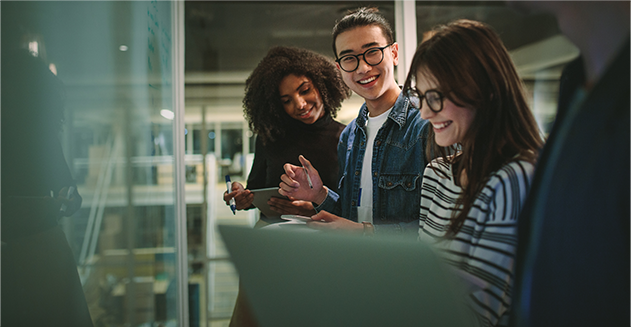 Three students gathered together around a computer.